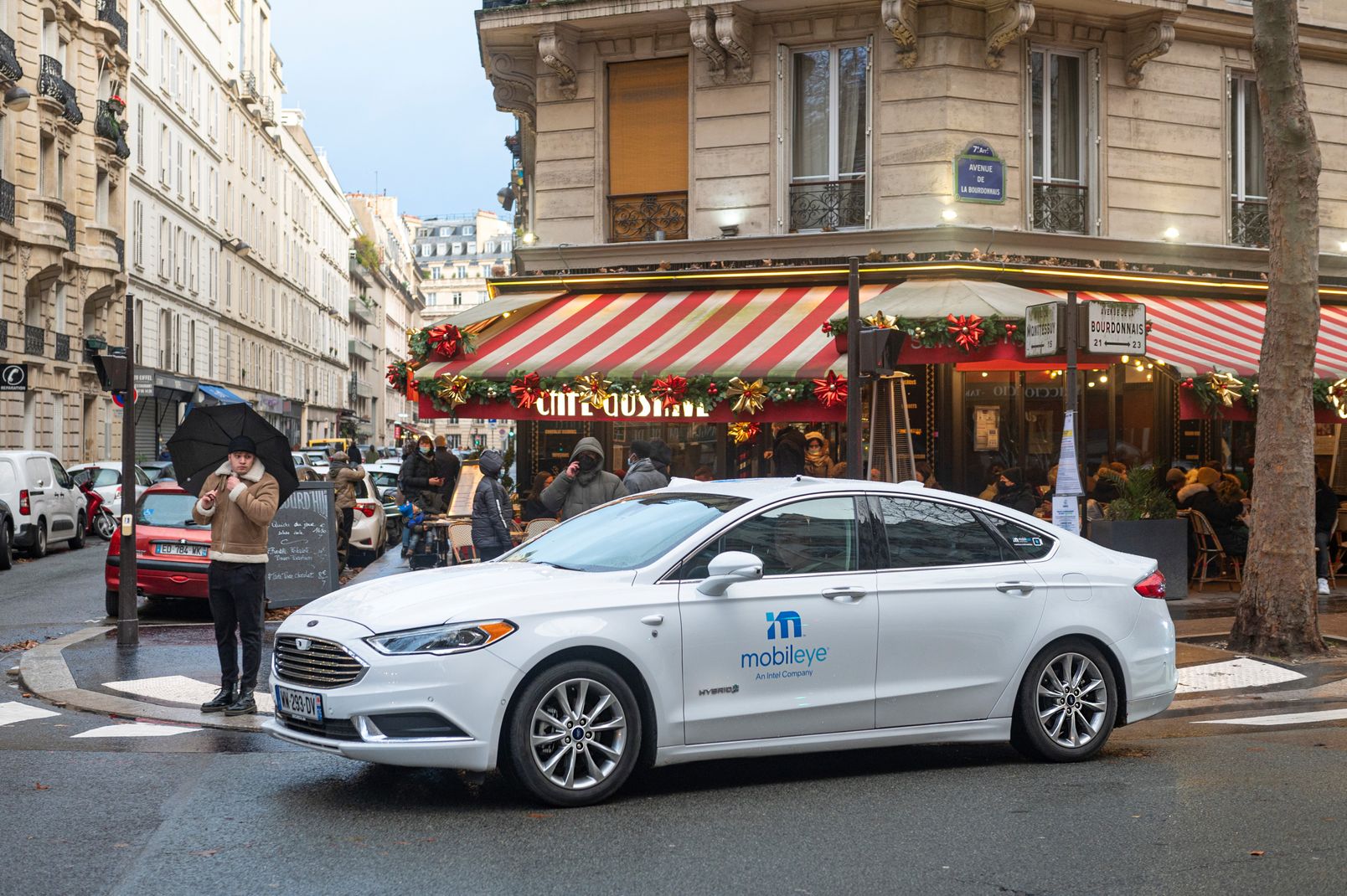Mobileye autonomous vehicle outside a street corner cafe in Paris