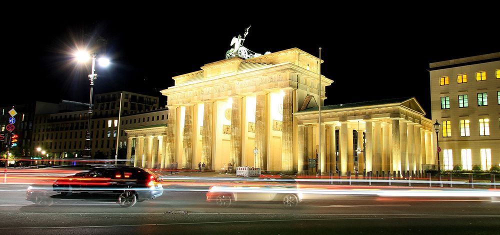 Traffic at night passing by the Brandenburg Gate in Berlin, Germany